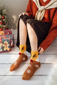 Detail of warm coral fleece Christmas socks with 3D reindeer design and snowflake patterns