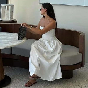Elegantes weißes trägerloses Maxikleid aus Baumwoll-Leinen an einem Model im Innenraum