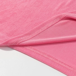Detailed macro view of the pink ribbed knit fabric texture and fine stitched hemline seam