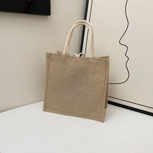 Detailed close-up of a minimalist natural jute tote bag with thick braided rope handles