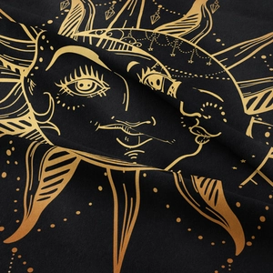 Close-up of black and gold sun and moon tapestry fabric showing detailed fiber texture
