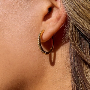 Macro view of 18K gold plated stainless steel hoop earring with sparkling white diamonds
