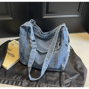 Gros plan d'un sac cabas en jean bleu avec bords effilochés et texture de tissu délavé