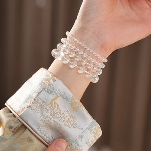Detailed view of four multi-layered white crystal bead bracelets with natural clarity