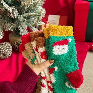 Close-up of thick coral fleece Christmas socks with festive holiday patterns and warm texture