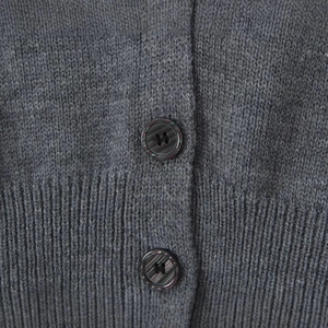 Gros plan d'un cardigan gris foncé montrant la maille côtelée et deux boutons ronds
