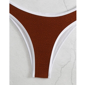 Detail der karamellfarbenen High-Cut-Bikininhose mit Seersucker-Struktur und weißer Paspel