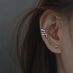 Close-up of a silver snake-shaped ear cuff featuring a winding serpentine design on ear