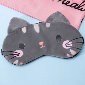 Cute gray plush cat sleep mask with embroidery and elastic band on light blue background
