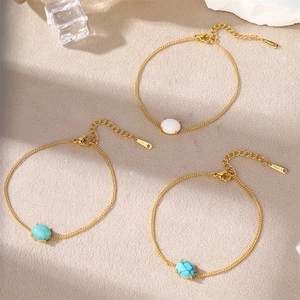 Detailed view of three 18k gold plated stainless steel bracelets with turquoise stones