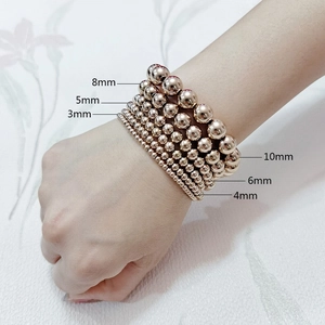 Detail of rose gold beaded bracelets in various sizes from 3mm to 10mm on wrist