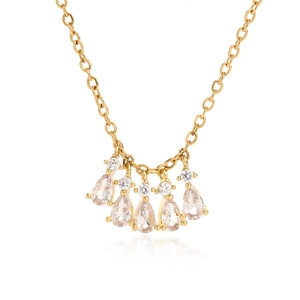 Macro detail of gold necklace with five pear-cut clear stones and round diamond accents