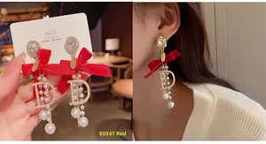Detail of S925 silver earrings featuring red silk bows and pearl-encrusted D charms