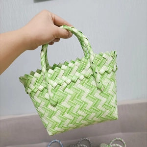 Detailed view of hand-held green and white checkered woven basket bag for summer gifts