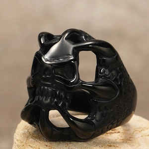 Detailed macro view of black gothic skull ring with intricate dragon scale textures