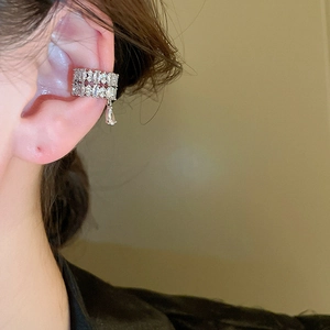 Close-up of double-layered silver ear cuff with sparkling zircon water drop pendant on ear