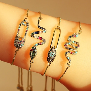 Detailed view of adjustable gold charm bracelets with colorful cubic zirconia stones
