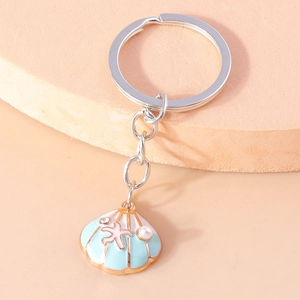 Detail of light blue shell keychain with pink starfish and pearl on a metal ring