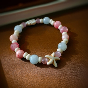 Détail du bracelet en perles macaron avec breloque étoile de mer et motifs de feuilles