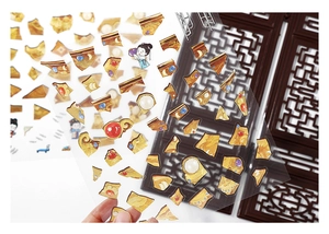 Macro detail of vintage style gold jewelry and antique character stickers on clear film