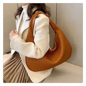 Close-up of brown woven leather texture on a stylish slouchy hobo shoulder bag