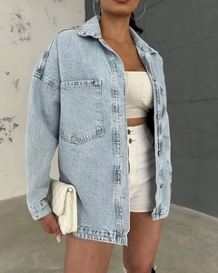 Detail of light blue washed denim jacket fabric texture and premium white stitching finish
