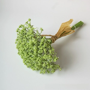 Detailed close-up of artificial green gypsophila bouquet with brown ribbon wrap