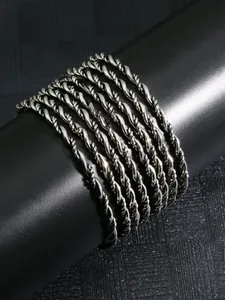 Close-up of silver braided twist rope bracelets on a black display stand