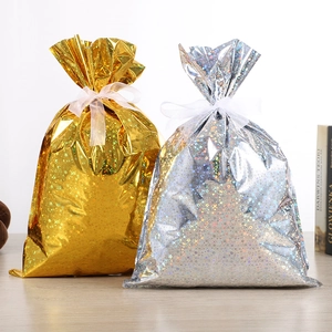 Détail des sacs cadeaux de Noël en film laser avec effet étoilé or et argent et rubans
