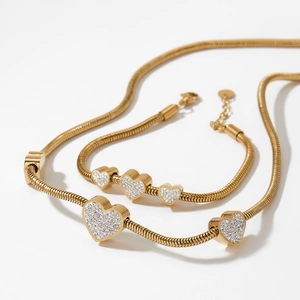 Golden heart jewelry set with necklace and bracelet featuring shiny clear crystals