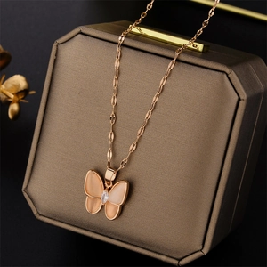 Rose gold butterfly pendant necklace with white shell on vintage jewelry box display