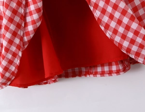 Gros plan détaillé de l'ourlet de robe à carreaux rouge et blanc avec doublure rouge