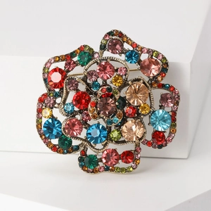 Detailed view of 3D rose brooch with colorful rhinestones on bronze hollow base