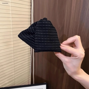 Detail of fabric polka dot triangle hair claw clip with black and white textile texture