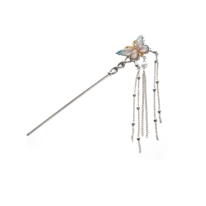 Detail of silver hair stick featuring blue enamel butterfly, pearl and long tassels