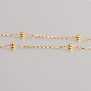 Close-up of polished 18K gold-plated double-layer bead chain with smooth finish