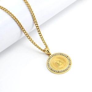 Macro view of gold plated round pendant with embossed pattern and inlaid diamonds