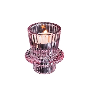 Pink fluted glass candle holder with vertical stripes and ruffled base on white background
