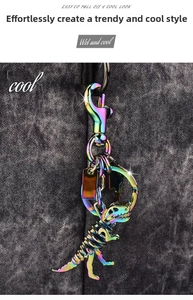 Iridescent metal dinosaur skeleton keychain detail on dark grey textured background