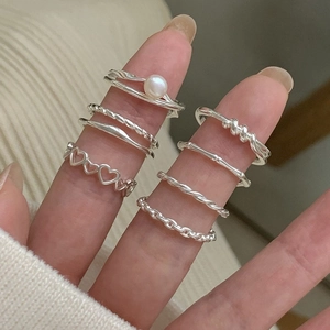 8-piece silver ring set featuring twist, heart, and pearl designs on fingers