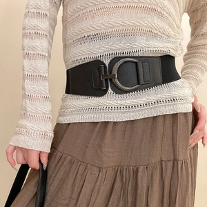 Détail de la boucle vintage en D sur une ceinture élastique noire en cuir