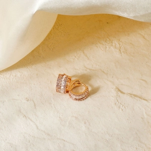 Elegant rose gold hoop earrings with square cubic zirconia on beige stone and silk