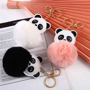 Detailed view of panda plush keychains with colorful fur balls and gold metal hardware