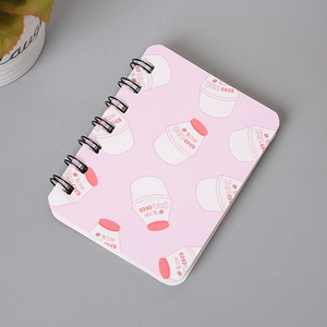 Detailed view of pink spiral notebook cover with strawberry milk design and black binding