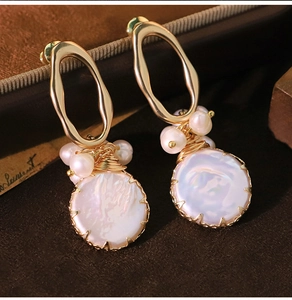 Detailed view of large oval baroque pearl earrings with gold wire-wrapped edges