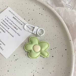 Detail of light green flower charm with white clasp on a ceramic plate background