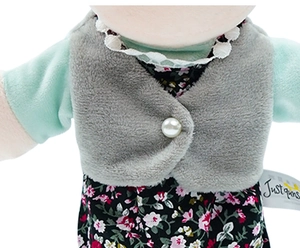 Detail view of plush puppet vest with pearl button and floral dress with Just For You label