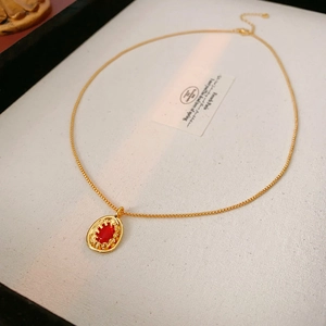 Detail of vintage gold necklace with oval red pendant inside a white jewelry gift box