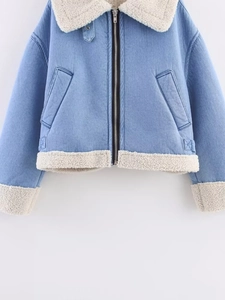 Detail of light blue denim jacket with cream faux shearling collar and metal zipper