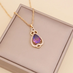Close-up of purple gradient teardrop pendant with micro-diamonds on a gold chain